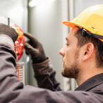 Electrician engineer tests electrical installations and wires on relay protection system. Bay control unit. Medium voltage switchgear