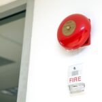 close-up-wall-mounted-red-fire-bell-flashing-warning-light-building-concepts-fire-alarm-prevention-safety-system_101448-1658